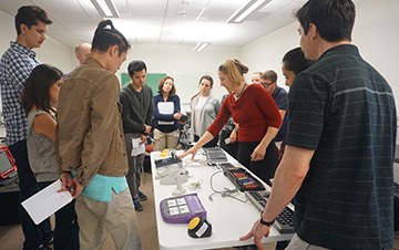 A C4AT staff member demonstrates an assistive technology device to a group